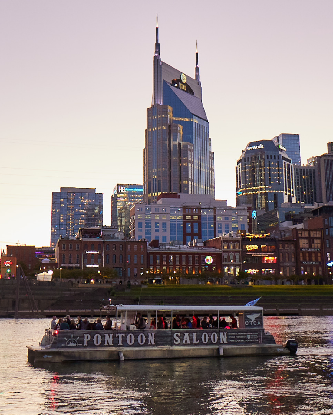 the pontoon saloon in front of the nashville skyline at sunset