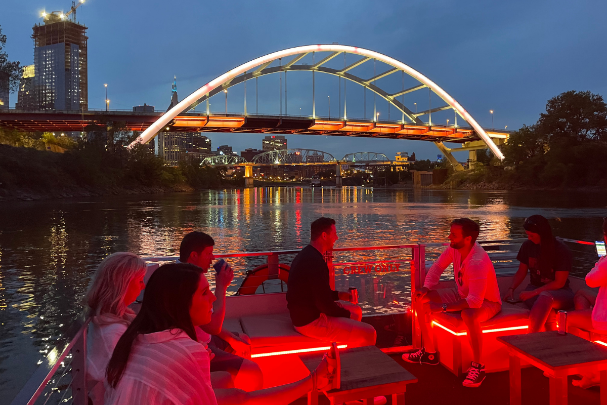 people on an evening river cruise in glowing lights