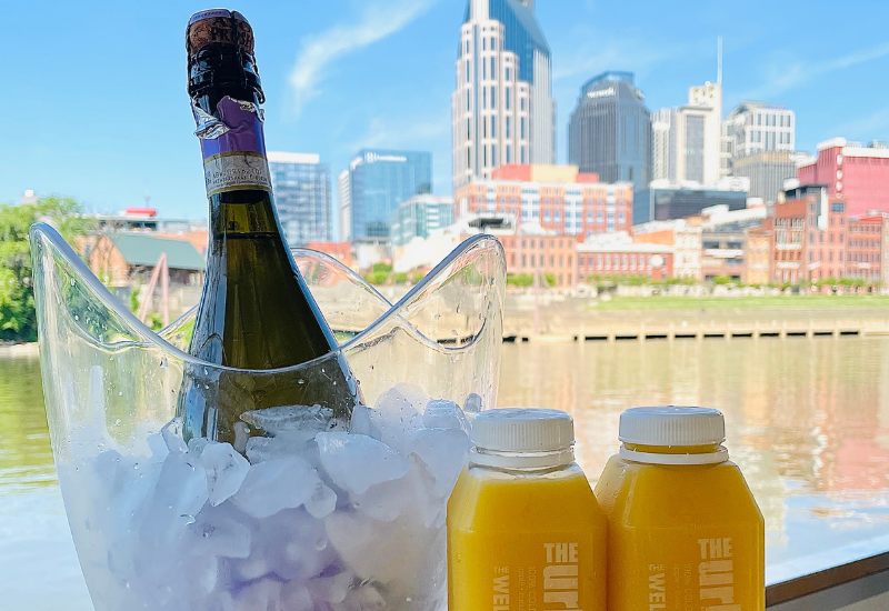 champagne on ice and orange juice in front of nashville skyline