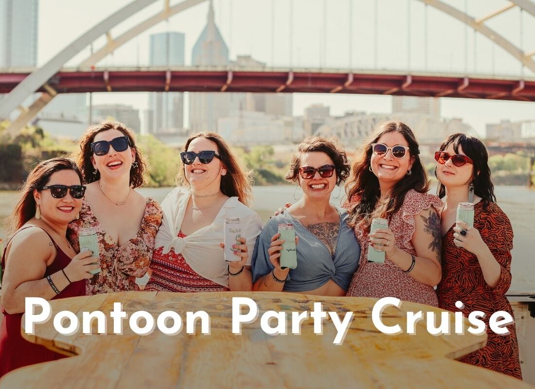 group of women holding cans in koozies while smiling on a pontoon party cruise